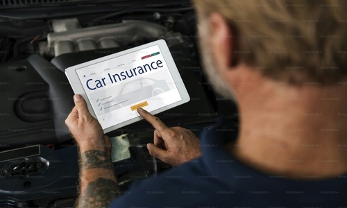 Man using a tablet to access car insurance services online, displayed against a vehicle background.