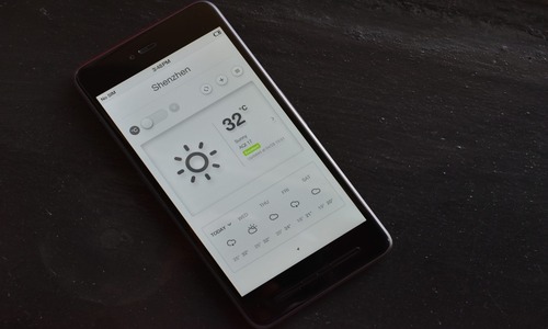 Weather app on phone showing 32°C in Shenzhen with sunny forecast and AQI 17 excellent air quality.