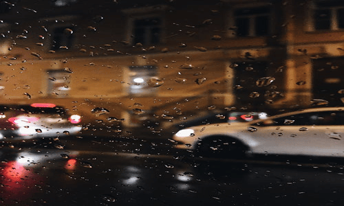 Close-up of water droplets on a glass surface symbolizing blurred view through window.